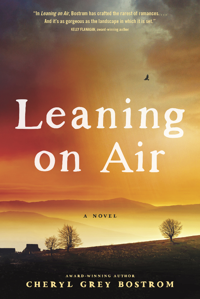 Picture of the book Leaning on Air book cover. It's a misty, golden sunset over rolling mountains.